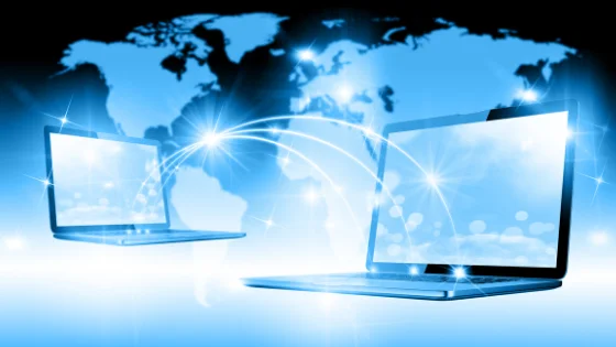 Illustration of two laptops connected across a world map representing global internet connectivity