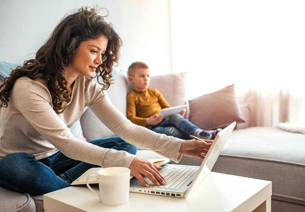 Mother working from home with son on technology